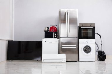 Yeni mutfaktaki yansıtıcı beyaz zeminde modern aletler seti