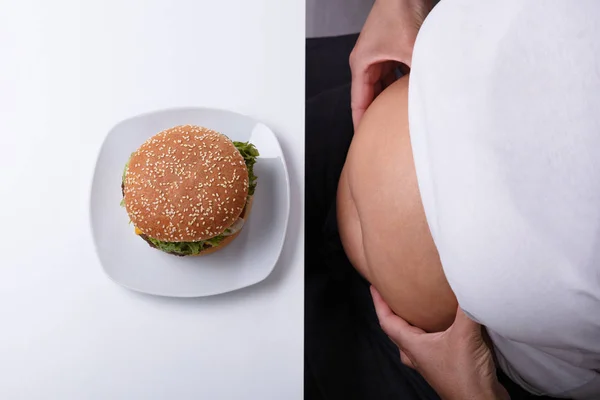 Overhead View Woman Pinching Her Fatty Stomach Hamburger Plate — Stock Photo, Image