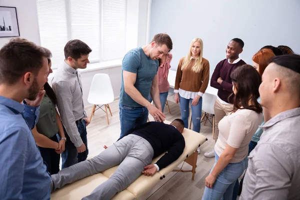 Männlicher Instruktor Lehrt Massagetechnik Für Gruppe Multiethnischer Menschen — Stockfoto