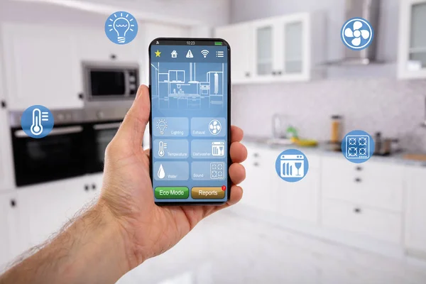 キッチンを背景にしたスマートホームコントロールアイコン機能付き携帯電話のクローズアップ — ストック写真