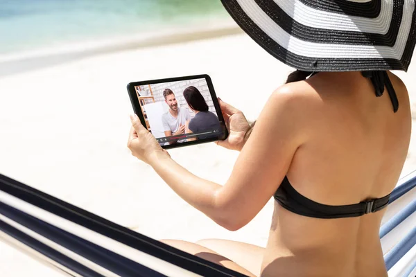 Kvinna Bikini Sittande Hängmatta Titta Video Digital Tablet Vid Stranden — Stockfoto