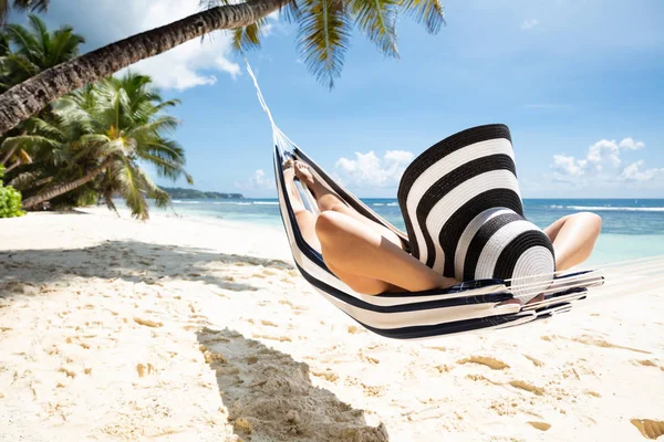 Женщина Полосатой Шляпе Отдыхает Гамаке Над Идиллическим Пляжем Летом — стоковое фото