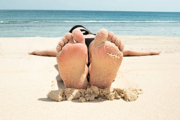 Närbild Ung Kvinna Som Ligger Sanden Med Hennes Kladdiga Feet — Stockfoto