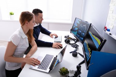 Iki Işadamlarının Iş yerindeki bilgisayarda grafiği Inceleyerek yan görünümü