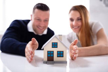 Yakın çekim çift 's koruma ev modeli üzerinde beyaz masa