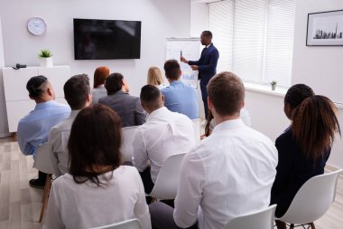 Ofiste Sandalyede Oturan Meslektaşlarına Sunum Yapan Yakışıklı Genç İşadamının Portresi