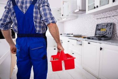 Üniforma Holding araç kutusunda bir tamirci arka görünümü mutfak Indüksiyon seramik Hob yükleme