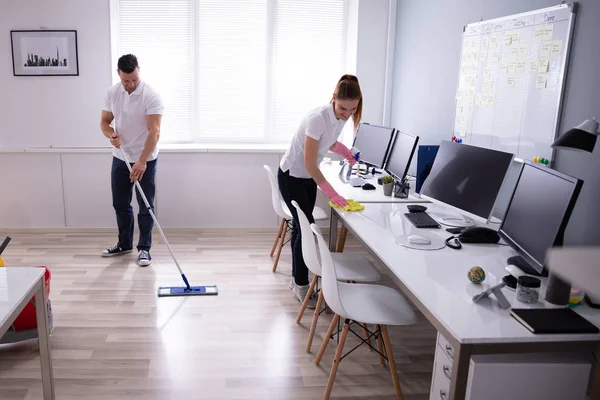 Dos Jóvenes Conserjes Sonrientes Limpiando Escritorio Limpiando Piso Oficina — Foto de Stock