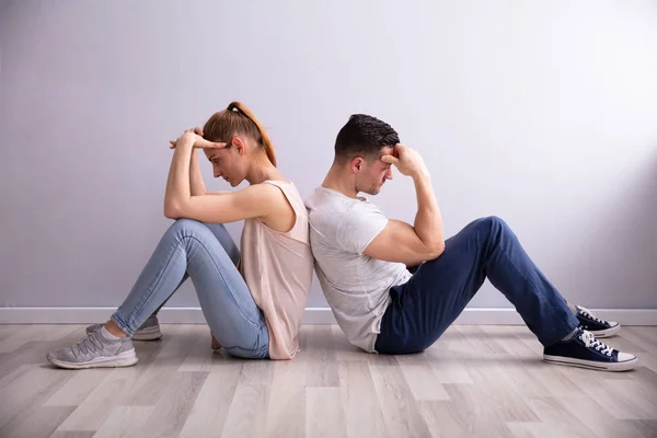 Triste Jovem Casal Sentado Volta Chão Casa — Fotografia de Stock