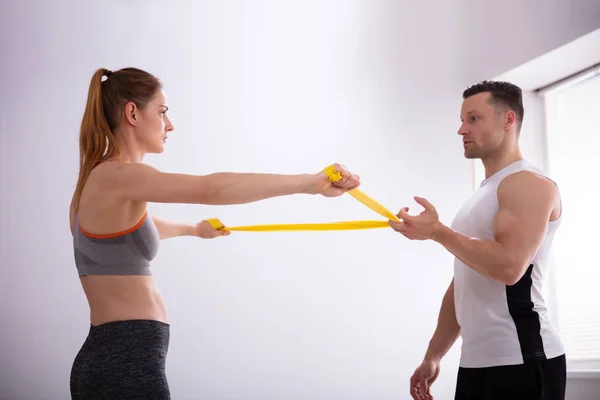 Vista Lateral Mujer Joven Entrenador Gimnasio Masculino Haciendo Ejercicio Con —  Fotos de Stock