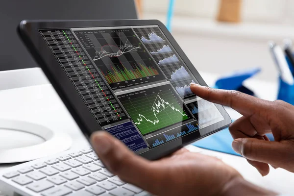 一个商人的特写镜头指向股票图表在平板电脑屏幕上 — 图库照片