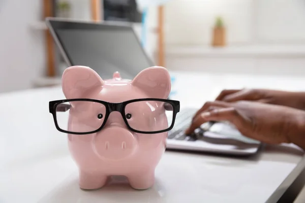 Närbild Rosa Piggy Bank Framför Affärsperson Som Använder Laptop Arbetsplatsen — Stockfoto