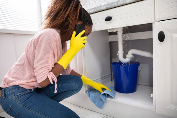 Close Young Woman Placing Blue Bucket Water Leaking Sink Pipe — Stock Photo, Image