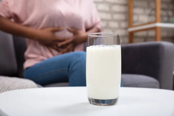 Женщина Страдающая Боли Животе Стаканом Молока Белом Столе — стоковое фото