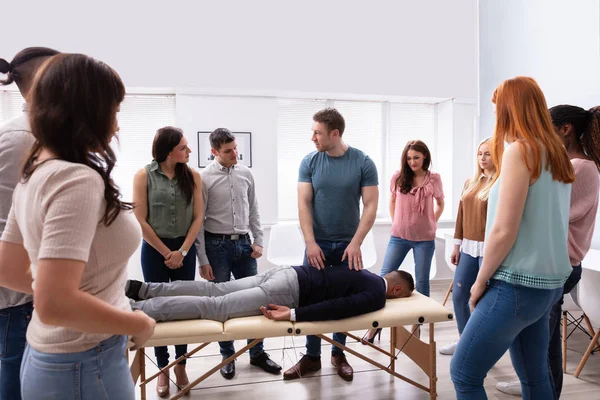 Männlicher Instruktor Lehrt Massagetechnik Für Gruppe Multiethnischer Menschen — Stockfoto