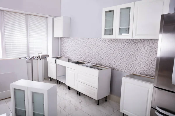 Installation Of Wooden Cabinets In The White Clean Modular Kitchen