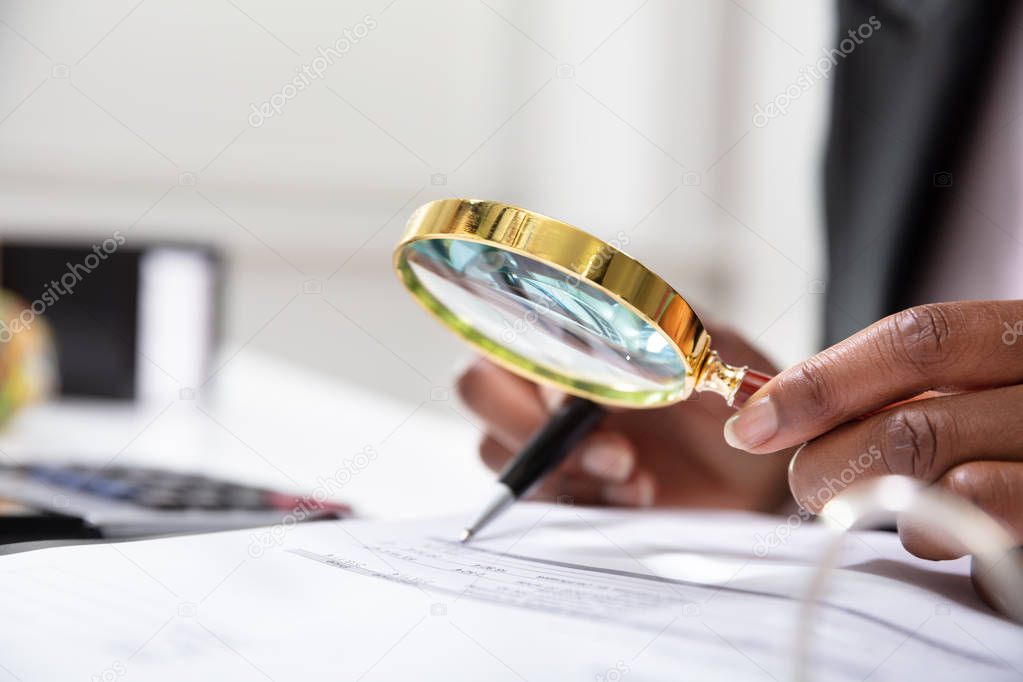 Photo Of Businessperson Examining Bill Through Magnifying Glass