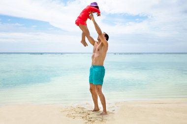 Gömleksiz baba sahilde kızı yüksek atma