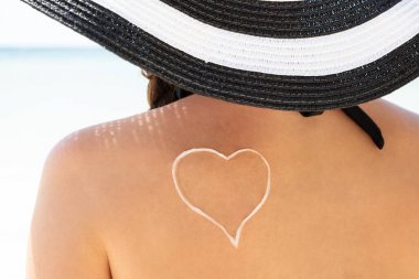 Arka görünüm arasında bir güzel kadın Ile Sunscreen Kalp Shape üzerinde onu sırt
