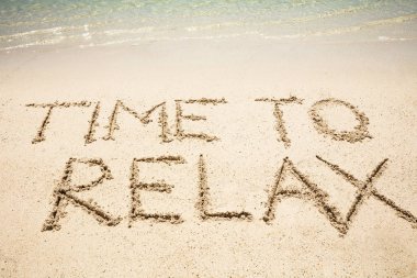 Kumsalın kıyısında kumlara yazılmış rahatlatıcı mesaj zamanı.