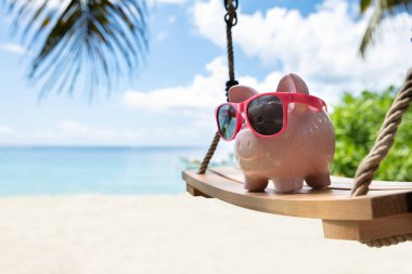 Plajda Ahşap Salıncak Üzerinde Güneş Gözlüğü ile Pembe Piggybank Close-up