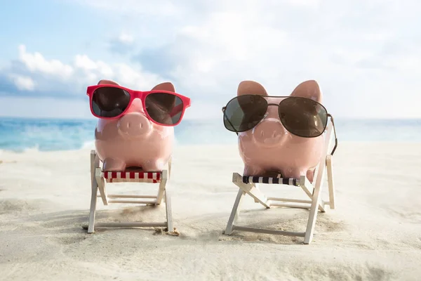 Zonnebril Twee Roze Piggybanks Miniatuur Stoelen Het Zandstrand — Stockfoto