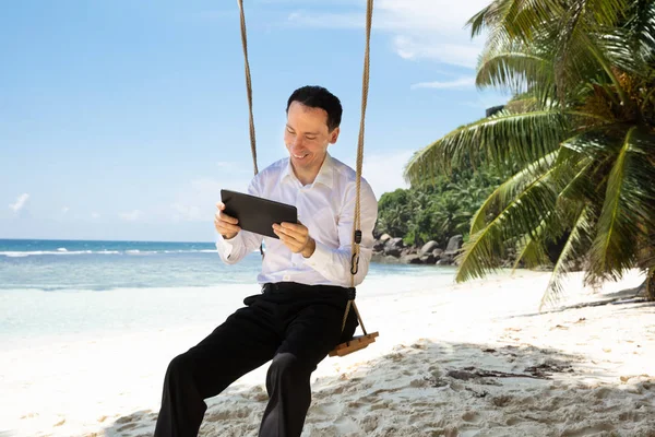 Man Sitting Swing Using Digital Tablet Sandy Beach Idyllic Sea — Stock Photo, Image