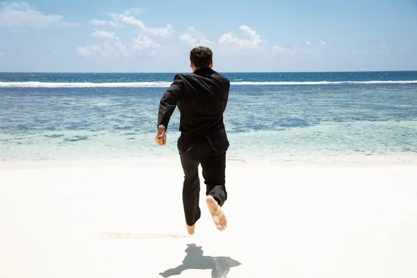 해변에서 목가적인 바다를 맨발로 달리는 사업가의 — 스톡 사진