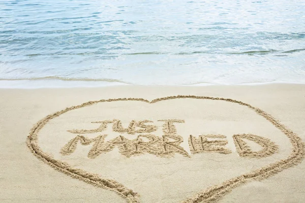 Just Married Written Text On Sand Near The Idyllic Sea At Beach