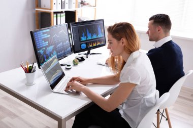 Erkek ve Kadın Borsa Broker Ofiste Bilgisayar Grafikleri Analiz