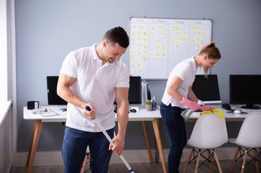 İki gülümseyen genç hizmetli büro temizlik ve ofis zemin mopping