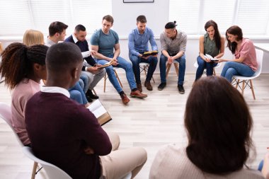 Group Of Young Multi-ethnic People Reading Holy Bible Together clipart