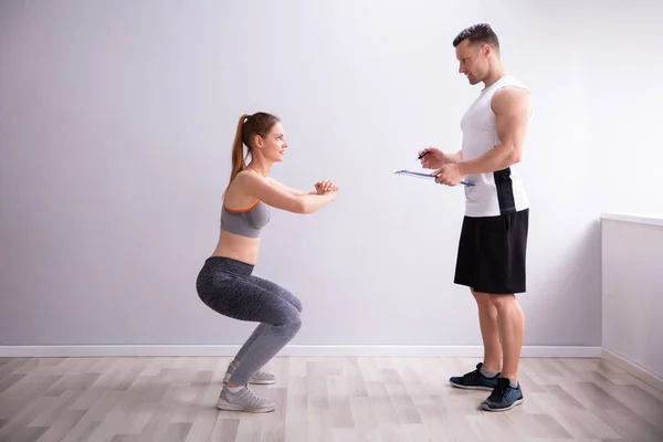 Oldalnézetből Fiatal Sportos Csinálás Deep Squat Gyakorlat Előtt Gym Trainer — Stock Fotó