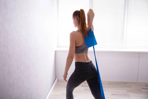 Jovem Mulher Alongando Com Cinto Ioga Enquanto Faz Exercício Casa — Fotografia de Stock