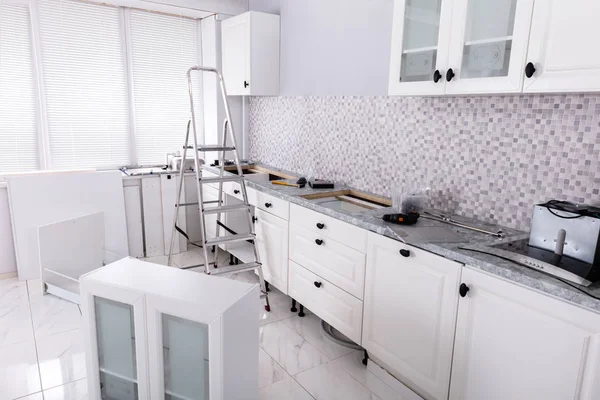 在新模块化房屋中安装带工具和梯子的白色机柜 — 图库照片