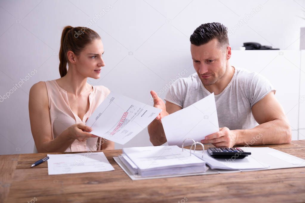 Young Couple Arguing About Expensive Invoice At Home