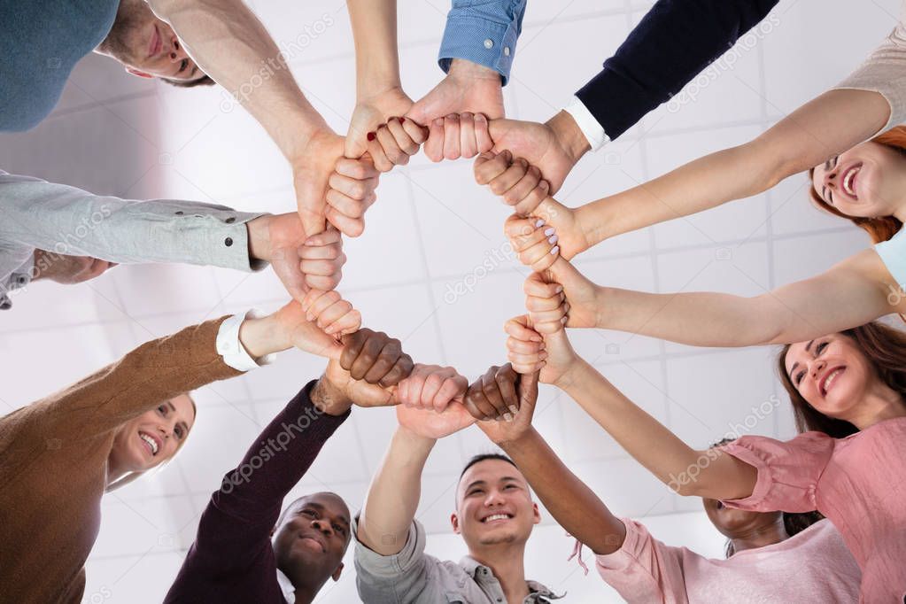 Multi-ethnic Group Of People  Holding Each Other Thumbs Forming Circle