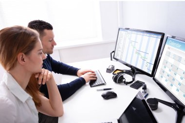 Gantt Çizelgesini Analiz Eden Genç İş Adamları ve Ofisteki Bilgisayarda Takvim