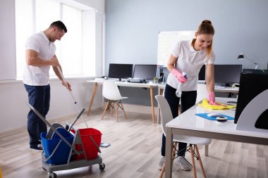 İki gülümseyen genç hizmetli büro temizlik ve ofis zemin mopping