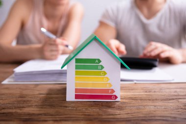 Hesap Makinesi Kullanarak Çift Önünde Enerji Verimliliği Oranı Gösteren Bir Evin Yakın Çekim