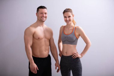 Gri Arka Plan Karşı Gülümseyen Sportif Çift Fotoğraf