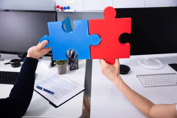 Close Két Businesspeople Kezében Vörös Kék Puzzle Munkahelyen — Stock Fotó