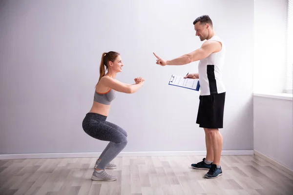 Oldalnézetből Fiatal Sportos Csinálás Deep Squat Gyakorlat Előtt Gym Trainer — Stock Fotó