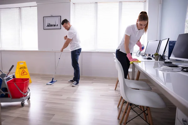 Twee Glimlachende Jonge Conciërge Het Schoonmaken Van Het Bureau Dweilen — Stockfoto