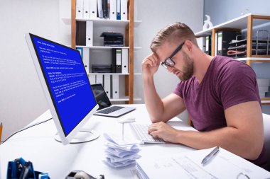 Worried Man At Computer With System Failure Screen At The Workplace clipart