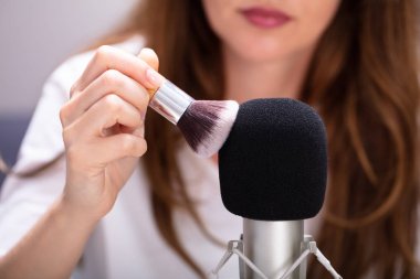 Asmr sesleri yapmak için mikrofonda fırça kullanan kadın