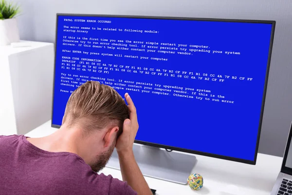 職場でのシステム障害画面を持つコンピュータで心配している男 — ストック写真