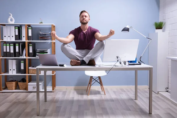 Ofiste Resepsiyon meditasyon üzerinde oturan genç işadamı