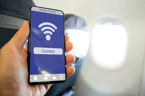 Uçakta Kablosuz Bağlantı Gösteren Kişinin Elini Tutan Cep Telefonunun Yakın — Stok fotoğraf