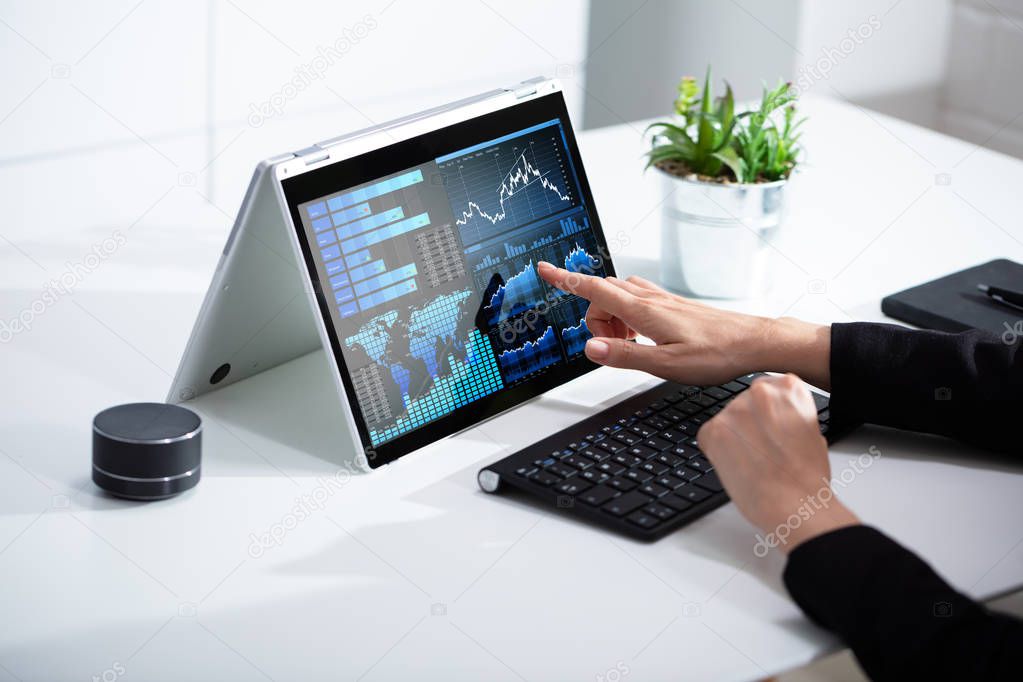 Close-up Of Businesswoman Analyzing Graph On Laptop At Workplace In The Office